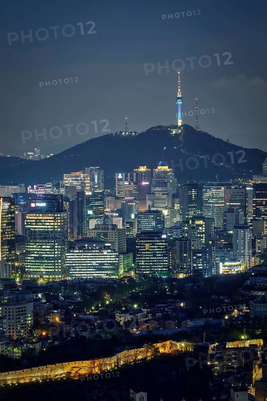 Seoul downtown cityscape illuminated with lights and Namsan Seoul Tower in the evening view from Inwang mountain. Seoul, South Korea