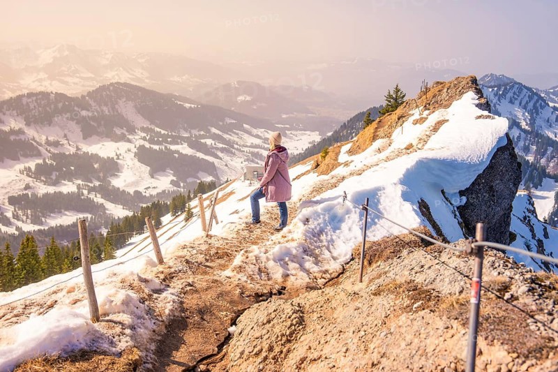 Person on a mountain trail surrounded by snowy landscapes, Hochgrat Mountains, Allgäu Alps, Oberreute, Germany