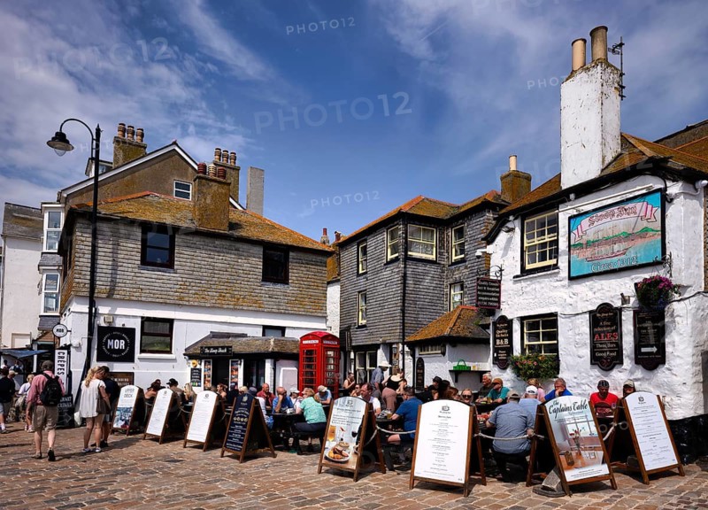 People, tourists, sit on the terrace of the Sloop Inn, one of Cornwall's oldest inns, St Ives, Cornwall, England, Great Britain