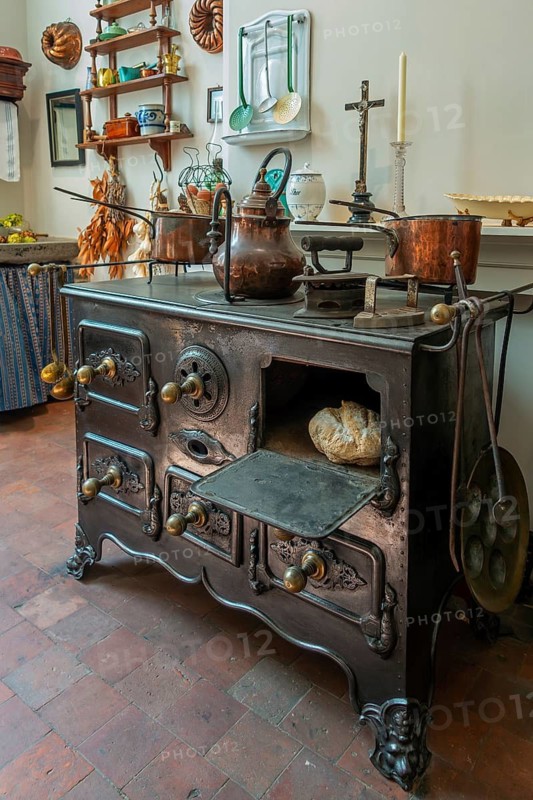 Antique cast-iron stove in kitchen inside 18th century clergy house Schriek at recreated village in open air museum Bokrijk, Limburg, Belgium