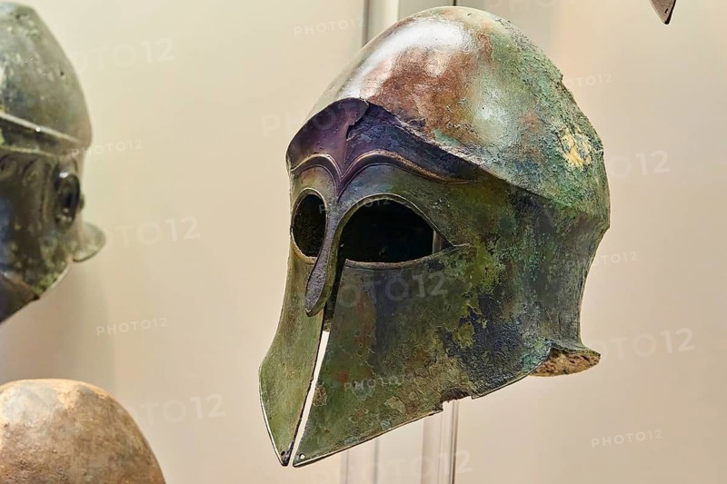Corinthian bronze helmet, an ancient warrior helmet with green patina and distinctive design, Olympia Archaeological Museum, Ancient Olympia, Olympia, Peloponnese, Greece