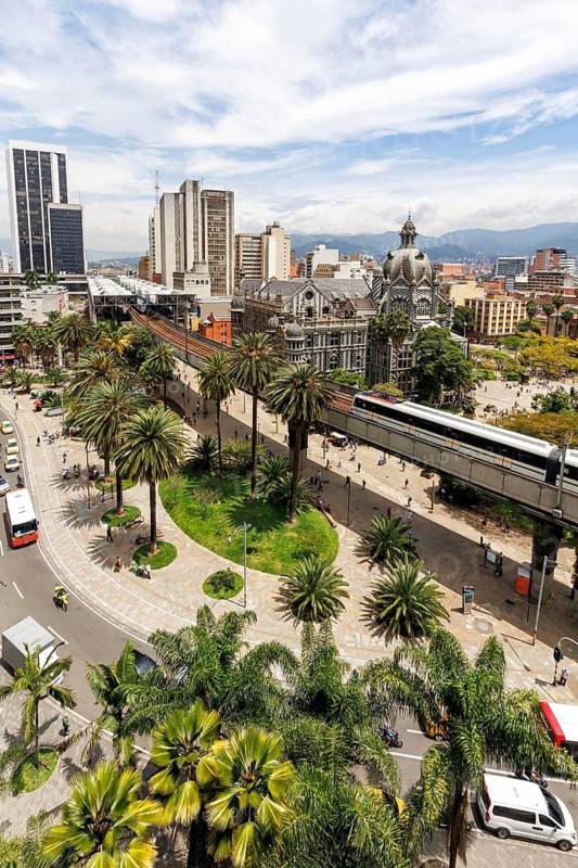 Medellin skyline with a train of the Metro de Medellín at Plaza Botero in Medellin, Colombia