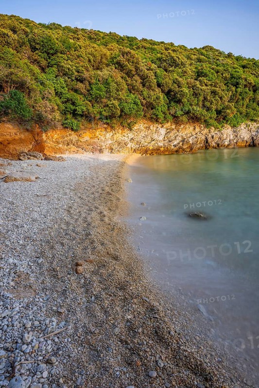 Crystal clear and turquoise water on the beach of Ustrine Bay on a sunny day at sunset on the island of Cres, long exposure, Croatia