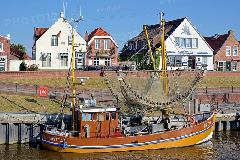 Crab cutter in the harbour in front of historic buildings, blue sky, Greetsiel, North Sea, Lower Saxony, Germany