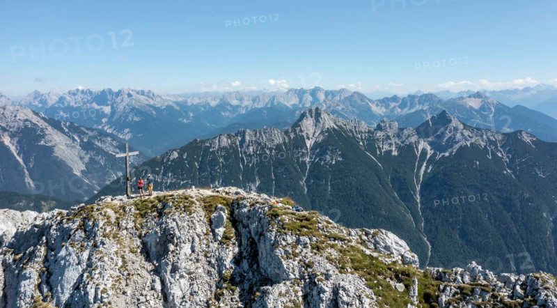 Aerial view, Alpine panorama, hikers at the summit cross, Westliche Wettersteinspitze, Wetterstein Mountains, Bavaria, Germany