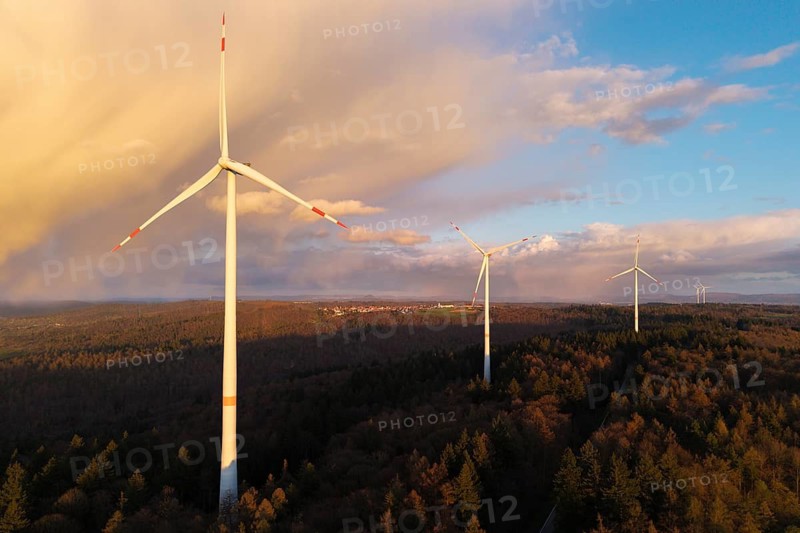 Three wind turbines looking up in a wooded landscape against a blue sky, wind turbine, near Schorndorf-Winterbach, Baden-Württemberg, Germany