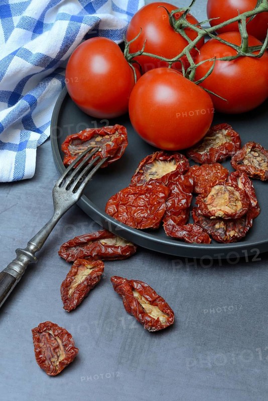 Fresh and dried tomatoes on a plate, Solanum lycopersicum
