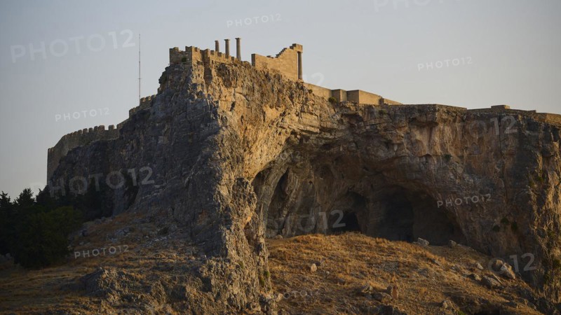 An ancient castle on a rock during the golden hours of sunset, Acropolis of Lindos, Lindos, Rhodes, Dodecanese, Greek Islands, Greece