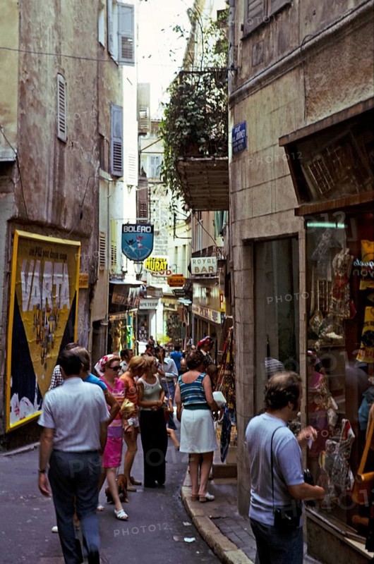 People shopping in a busy alley in Grasse, Côte d'Azur, France 1974