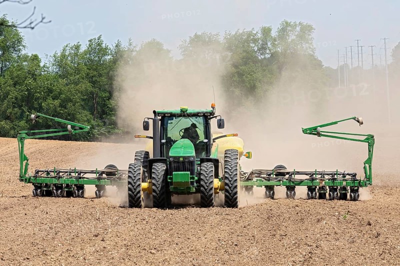 Albion, Michigan, A cloud of dust blows behind the tractor as a farmer tills his field