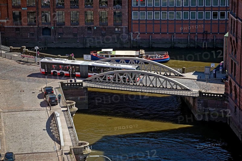 An articulated bus on the small Pickhuben bridge and a ship on Brooksfleet seen from above, Speicherstadt, Hamburg, Germany