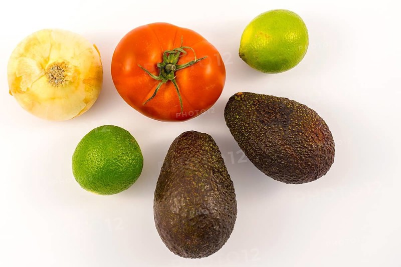 Two good avocados, two limes, an onion, and a tomato. Recipe to make a nice guacamole