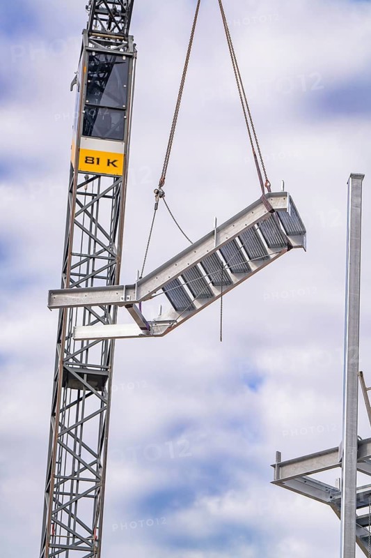 Close-up of a steel girder hanging from a crane on a construction site, staircase extension to the new tower of the Calw railway station on the new track of the Hermann Hessebahn, Calw, Black Forest, Germany