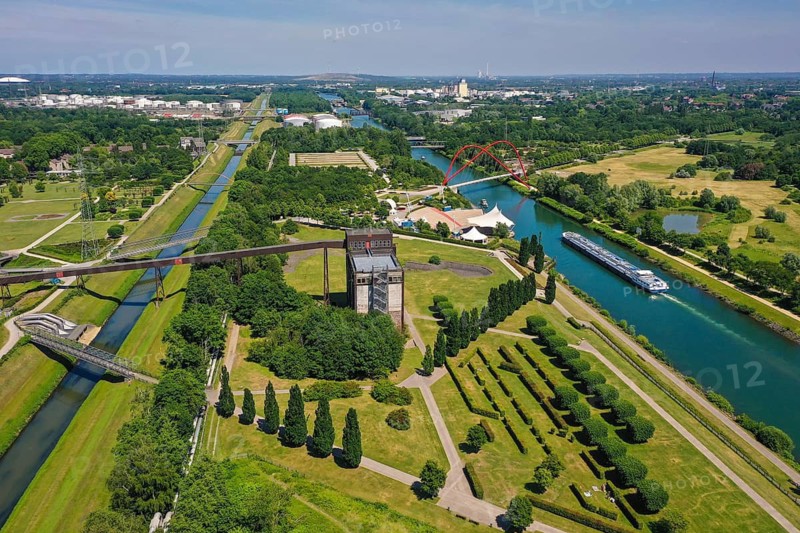 30.07.2022, Gelsenkirchen, North Rhine-Westphalia, Germany, Nordsternpark, here with the building of the coal mixing plant of the former Nordstern colliery, with the double arch bridge and the open-air stage amphitheatre on the Rhine-Herne Canal and to the left of the Emscher. Parks and gardens in the Ruhr area. Nordsternpark is a landscape park on the site of the former Nordstern colliery in Gelsenkirchen. Following the closure of Nordstern colliery in 1993, the site was completely renovated and transformed into a landscape park. The Federal Garden Show was held in the park in 1997. The site will be further redesigned as part of the IGA 2027. 00X220730D027CARO (MODEL RELEASE: NO, PROPERTY RELEASE: NO (c) caro images / Rupert Oberhaeuser, http://www.caro-images.com, info@caro-images.com, If the photo is used for purposes other than journalism, please contact the agency, Any use of the photo is subject to a fee !)