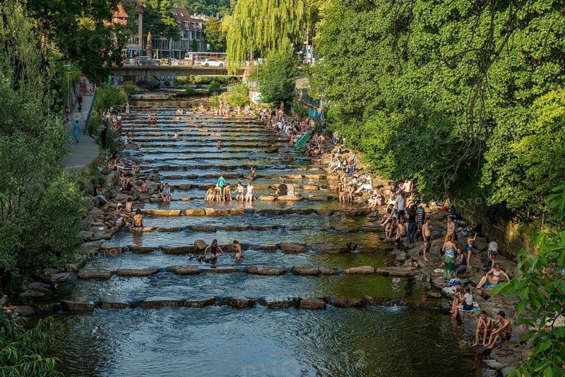 Young people sitting by and in the river, bathing in the city, heat, heat wave, climate change, Dreisam, Freiburg im Breisgau, Black Forest, Baden-Württemberg, southern Germany, Germany