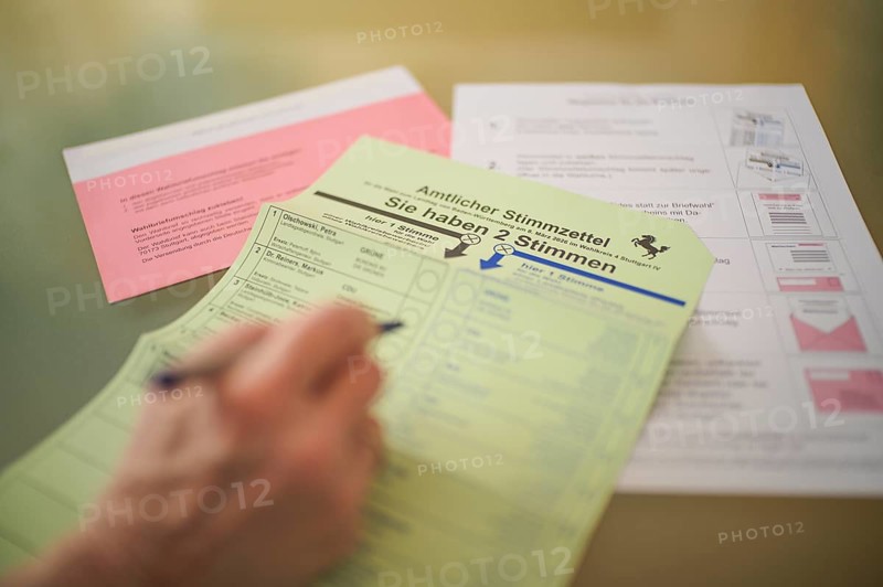 Voting, woman holding ballpoint pen, fills out ballot papers, votes, absentee ballot, official postal ballot documents, envelope, ballot envelope, instructions, election, parliamentary election, 2026 state election, Stuttgart, Baden-Württemberg, Germany