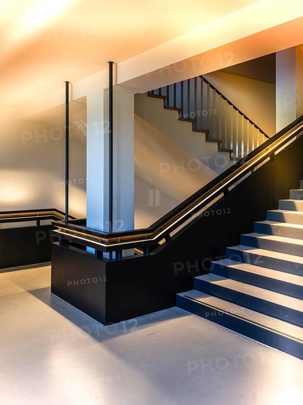 Carefully restored stairwell of the West Head Tower with newly developed steel staircase, which was installed hanging over the existing stairs while maintaining the old monumental staircase, former Tempelhof airport, Berlin, Germany