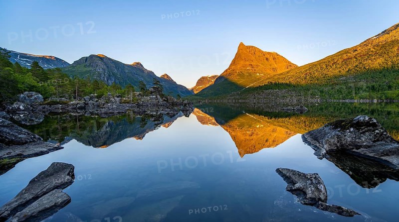 Picturesque mountain landscape with Innerdalstårnet peak in the Innerdalen high valley, mountain peaks reflected in Lake Innerdalsvatna, in the evening light at sunset, Trollheimen Mountain Area, Sunndal, Møre og Romsdal, Norway