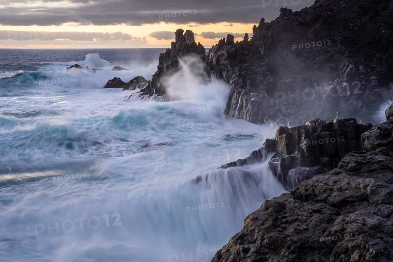 Waves break on the lava coast. In the evening. Charco Verde, La Palma, Canary Islands, Spain