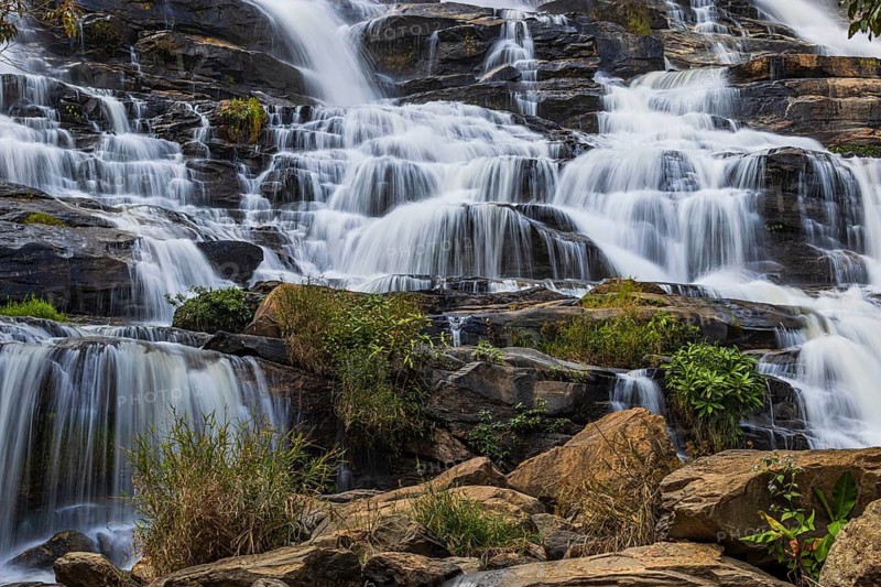 Mae Ya waterfall with cascading flowing water surrounded by lush tropical vegetation, near Doi Inthanon National Park, Chiang Mai Province, Thailand