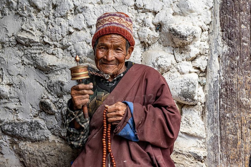 Elderly man with Buddhist stone mill and prayer necklace, Mala, in traditional dress, Lo Manthang, Mustang, Upper Mustang, former kingdom, Himalayas, Nepal