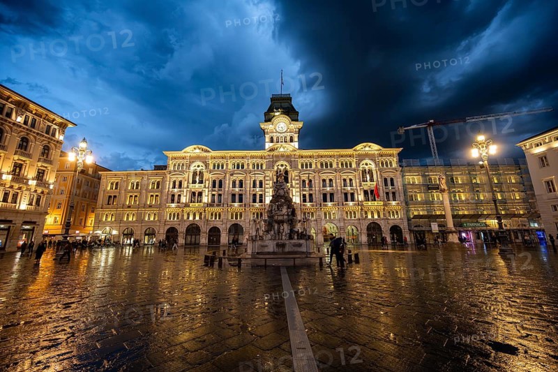Illuminated square Piazza Unità d'Italia, Town Hall, Palazzo Communale, with reflection, dramatic clouds, blue hour, old town, Trieste, Friuli-Venezia Giulia region, Italy