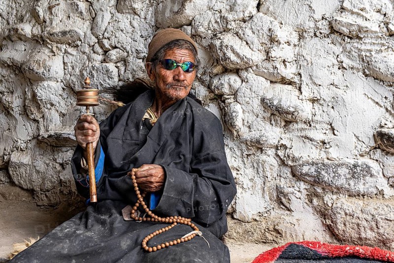 Elderly man wearing Buddhist stone mill and prayer necklace, Mala, in traditional dress, wearing modern sunglasses, Lo Manthang, Mustang, Upper Mustang, former kingdom, Himalayas, Nepal