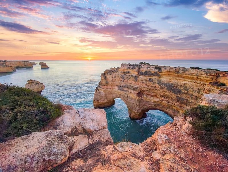 Sunrise at Praia da Marinha beach in Algarve, Portugal, with ocean cliffs, sea stacks and soft light over the cove