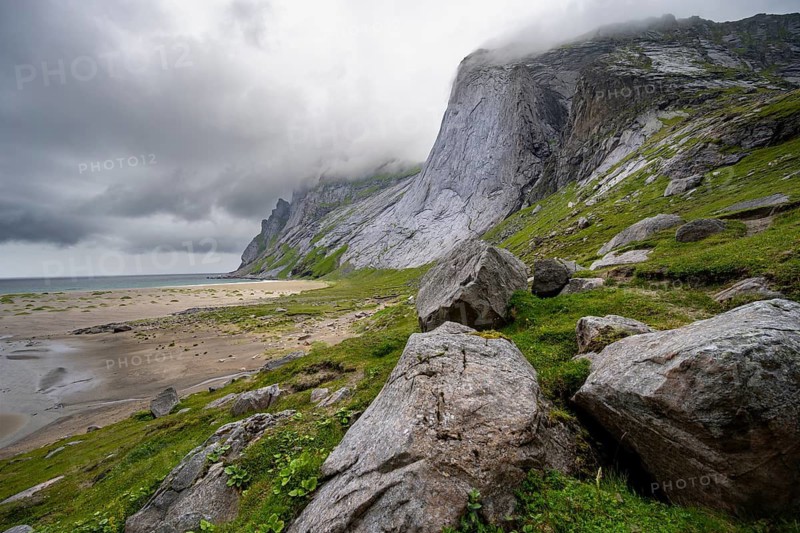 Bunesstranden sandy beach between rocky mountain peaks and dramatic clouds, Lofoten, Norway