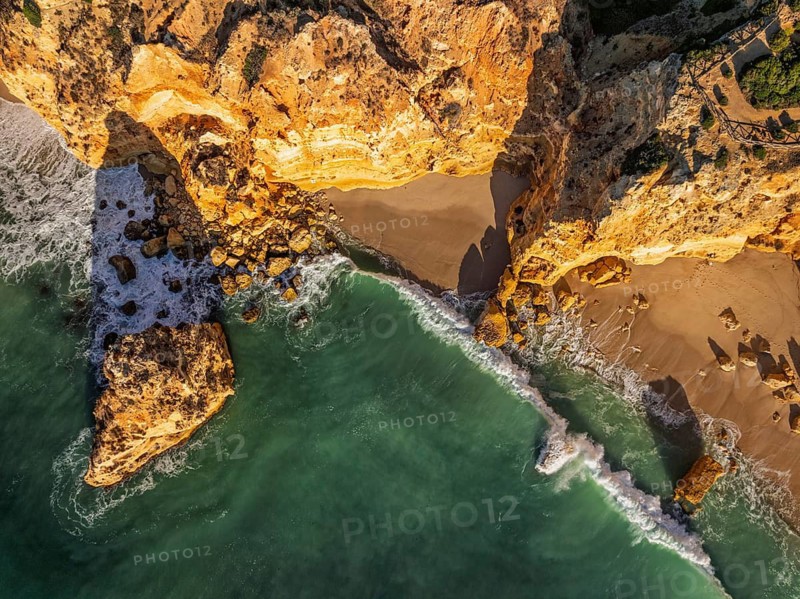 Drone top down view of Praia da Marinha beach in Algarve, Portugal, with ocean cliffs, sea stacks and sand and rocks
