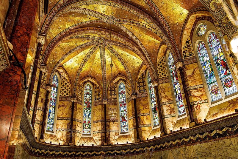 Gilded mosaic vaulting and stained glass windows illuminate the apse of the Grade II listed Fitzrovia Chapel, London, England, United Kingdom