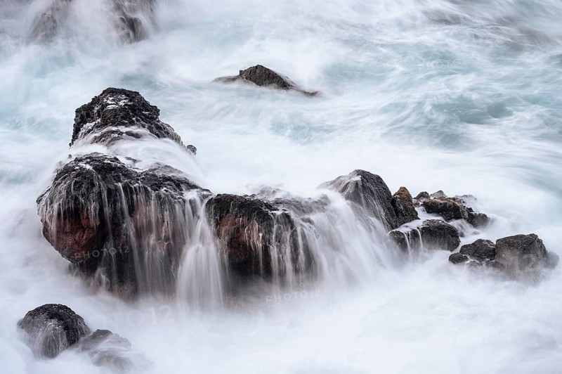 Rocks in the ocean, washed by waves. long exposure. Playa de Nogales, La Palma, Canary Islands, Spain