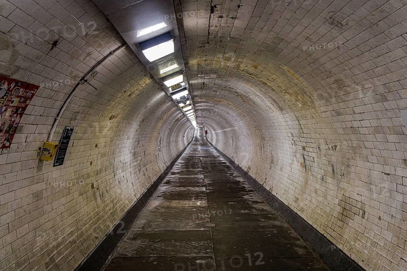 The white tiled curved passageway of the Greenwich Foot Tunnel running beneath the River Thames, London, England, United Kingdom