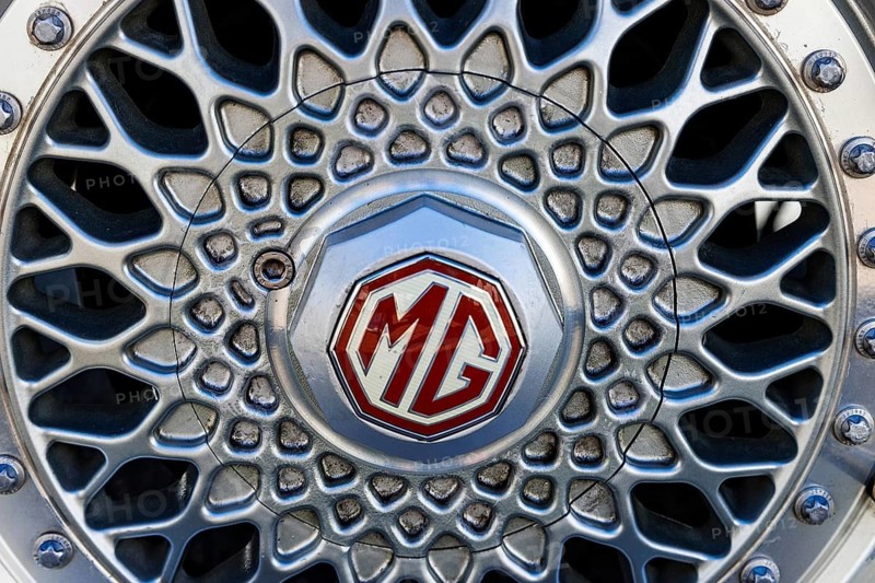 Alloy wheel with red and silver MG octagon badge on a classic MG sports car