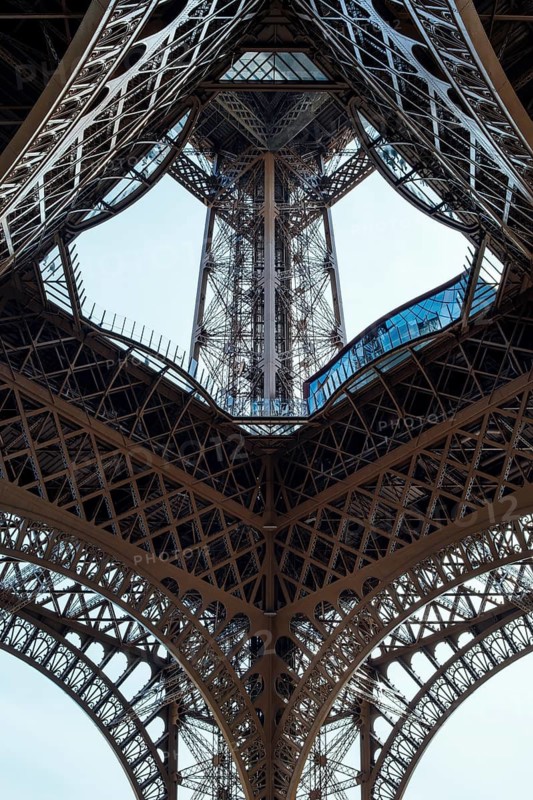 Portrait view of the complex metal structure and riveted struts of an Eiffel Tower pillar, close-up of the historical engineering of the late 19th century, Paris, Île-de-France, France
