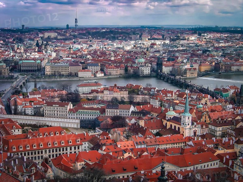 View from above of the old town of Prague, Vltava and Charles Bridge, panorama of a city with several bridges across a river, surrounded by historic buildings and a cloudy sky, Prague, Czech Republic