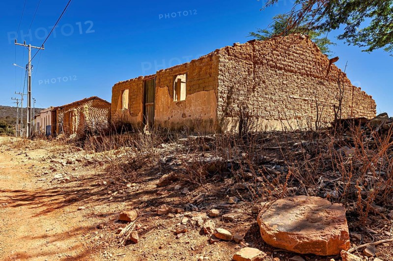 Dilapidated building in a dry landscape under clear skies, settlement and villages in the Caatinga of Pernambuco and Bahia in Brazil