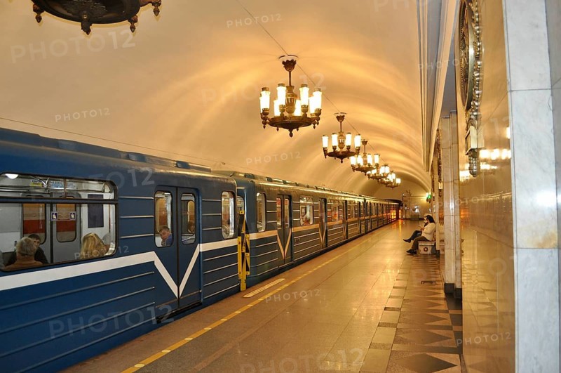 A train in a quiet subway station with ornate lights on the ceiling, metro, Saint Petersburg, St. Petersburg, Russia