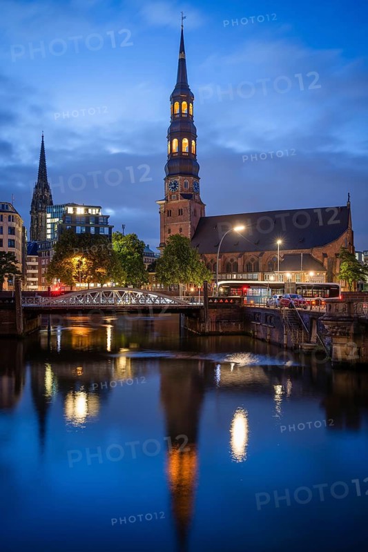 St. Katharinen's main church with reflection in the customs canal and St. Nikolai memorial at the Blue Hour, Hamburg, Germany