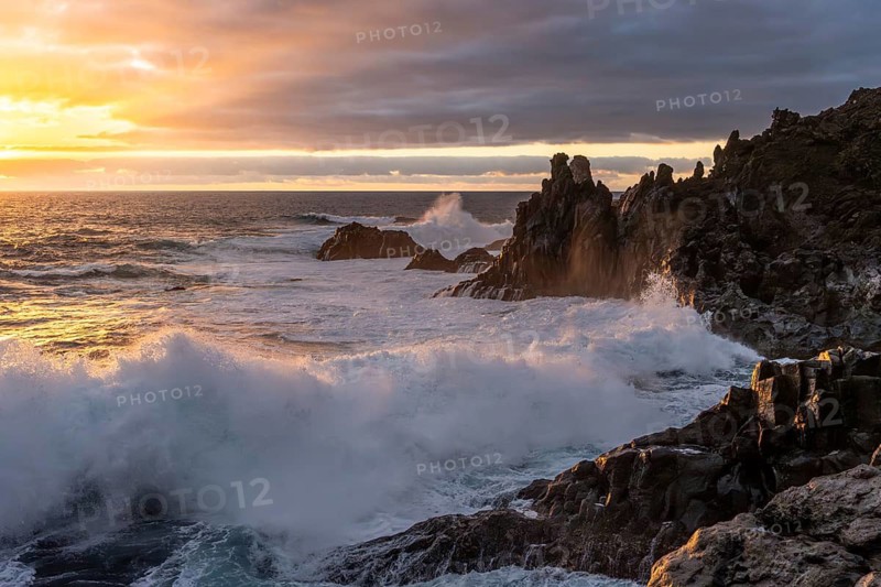 Waves break on the lava coast at sunset. Charco Verde, La Palma, Canary Islands, Spain