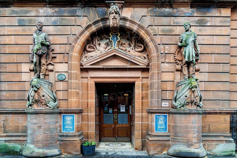 Ornately carved sandstone doorway flanked by statues of a mariner and shipwright at the Fairfield shipyard offices, Govan, Glasgow, Scotland, United Kingdom