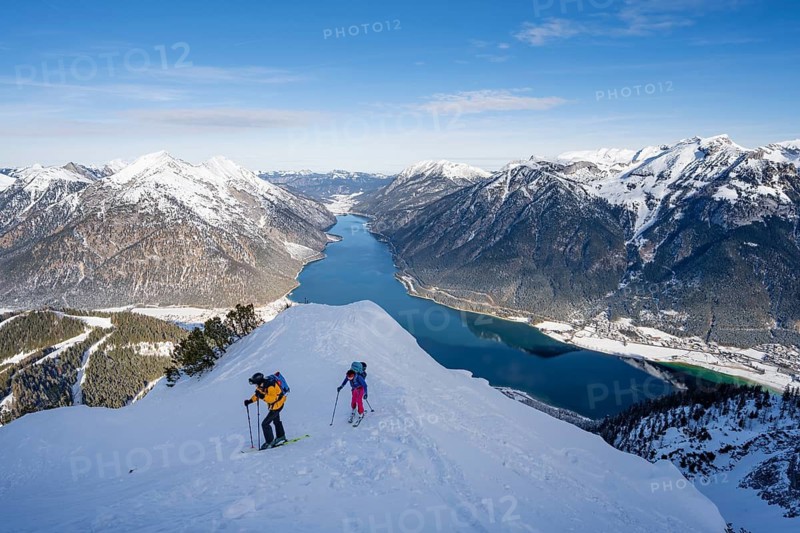 View of Achensee and wintry mountain scenery, ski tourers climbing to Bärenkopf, Achensee, Tyrol, Austria
