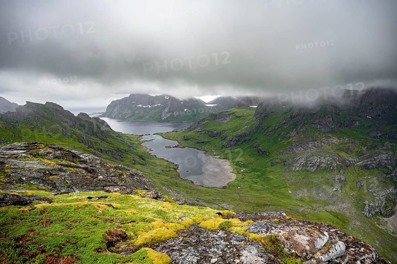 View over Bunesfjorden fjord, mountain peaks and dramatic clouds, climb to Helvetestinden summit, Lofoten, Norway
