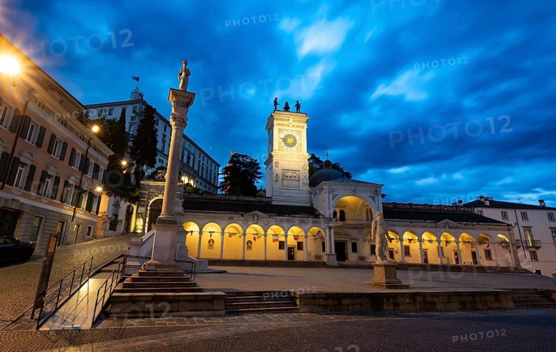 Illuminated main square Piazza della Libertà with Loggia e Tempietto di San Giovanni and clock tower, Castello di Udine behind, blue hour, dramatic sky, old town, Udine, Friuli-Venezia Giulia, Italy