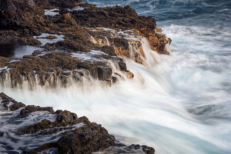 Seawater flows over lava rocks. long exposure. Coast near Charco Azul in the morning. La Palma, Canary Islands, Spain