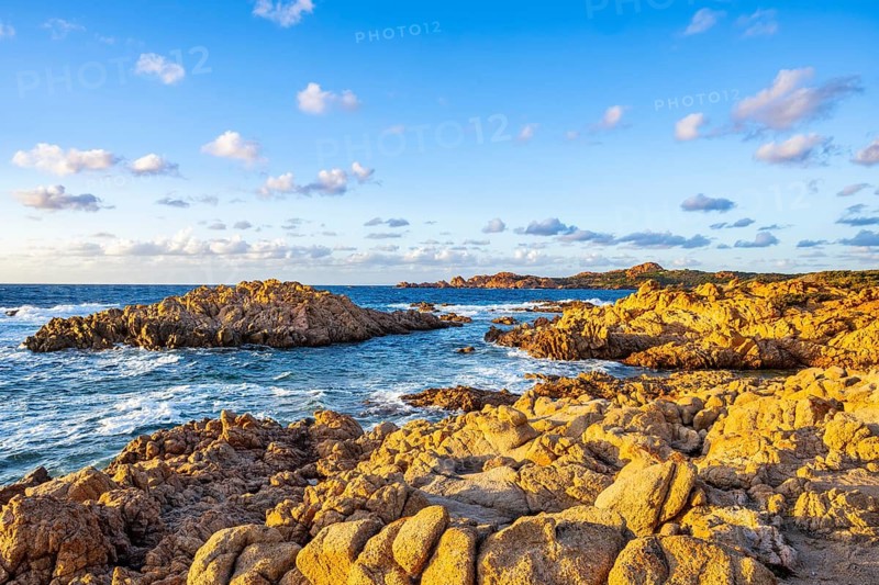 Landscape of the coastline with blue water at Marinedda Coast at sunset, Sardinia, Italy