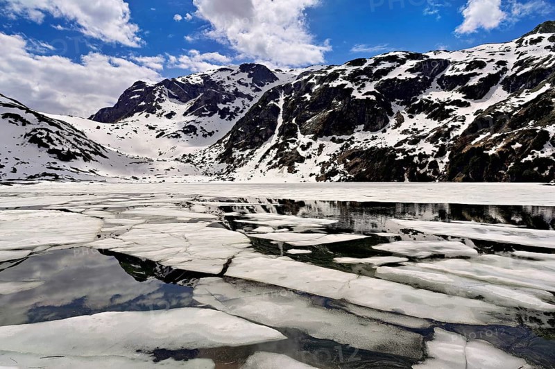 Ice floes float in the half-frozen Upper Murgsee, Murgtal, Canton of St. Gallen, Switzerland