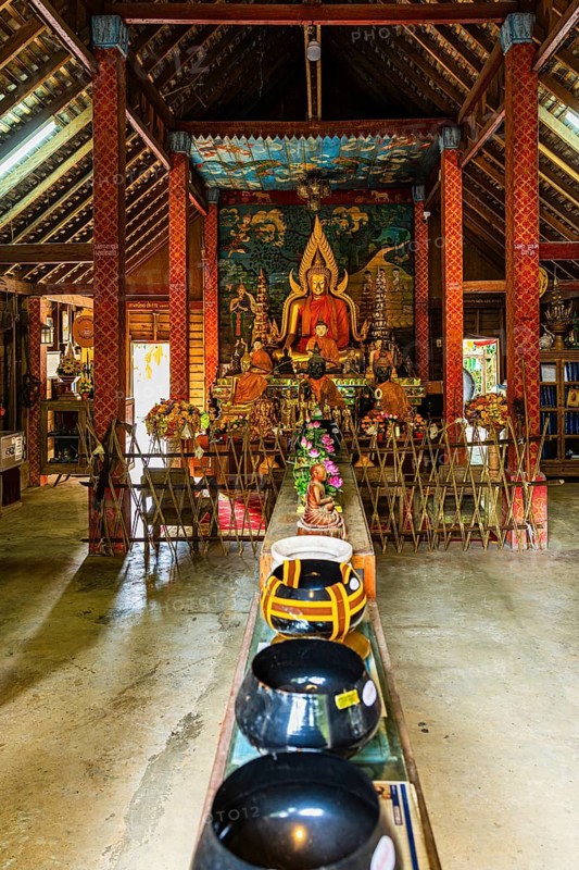 Buddhist temple, artfully designed interior with Buddha statue and offerings, Mae Kampong Village, Chiang Mai Province, Thailand