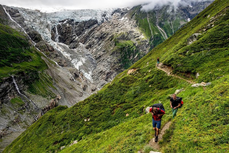 Mountaineers on a hiking trail, dramatic mountain landscape with Grindelwald-Fiescherfirn glacier, Bernese Alps, Bernese Oberland, Switzerland