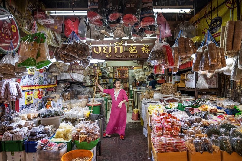 Bangkok, Thailand. August 24th 2026. A women wearing an elegant long pink dress working in a shop in a popular street market in the Chinatown district of Bangkok, Thailand, Asia